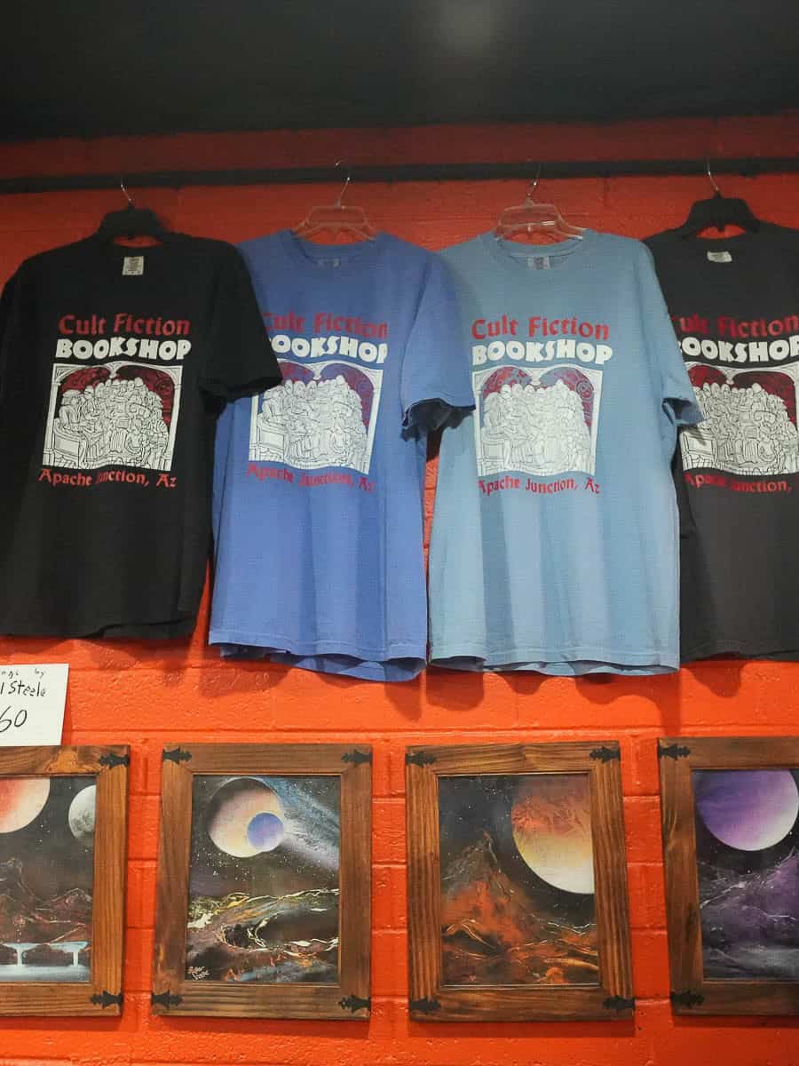 Cult Fiction Bookshop T-shirts with logo and artwork on display.
